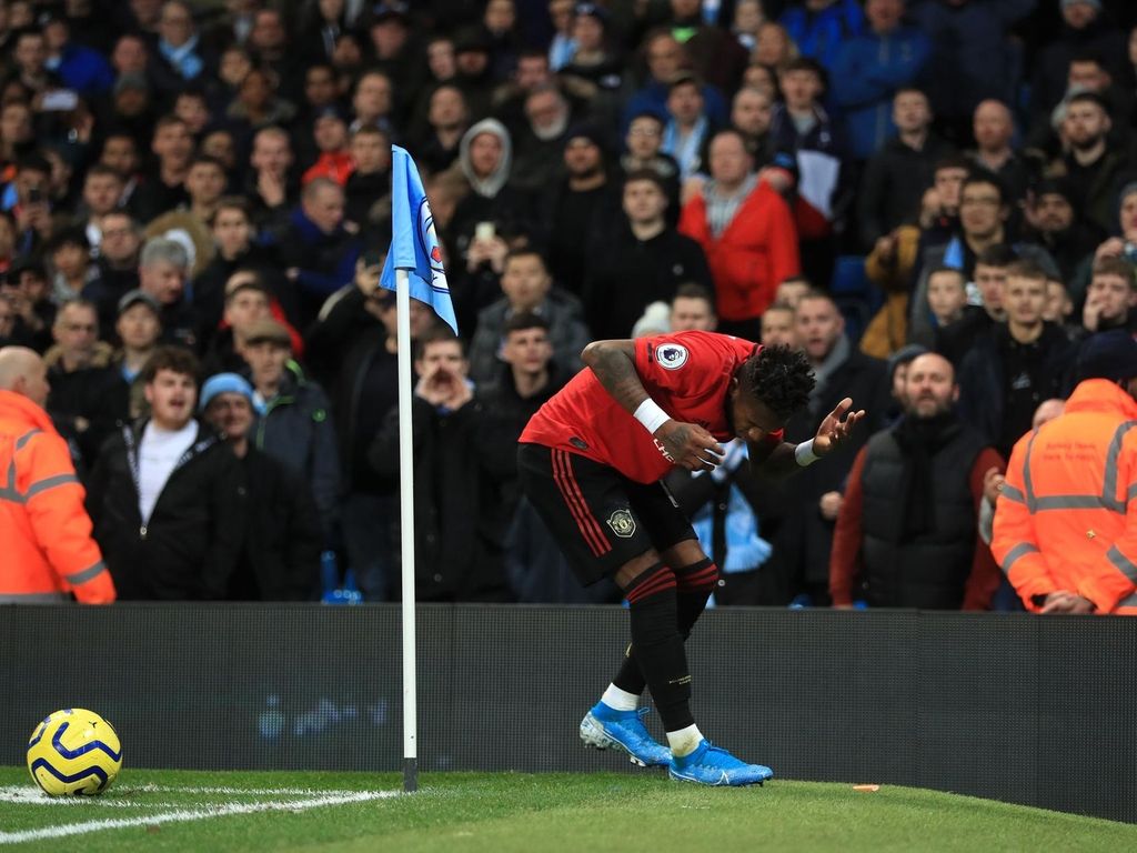Fred is hit by objects thrown onto the pitch during the Manchester derby. PA