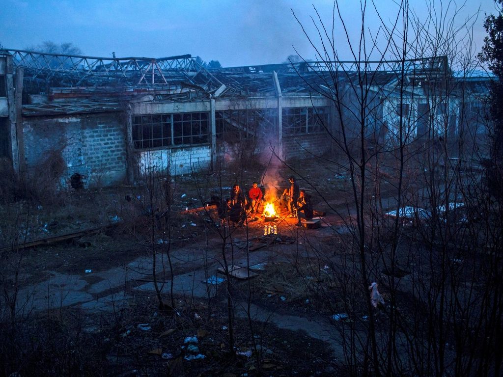 A group of Afghan migrants warm up in a bonfire next to an abandoned factory in the Bihac industrial area. JM Lopez / The National