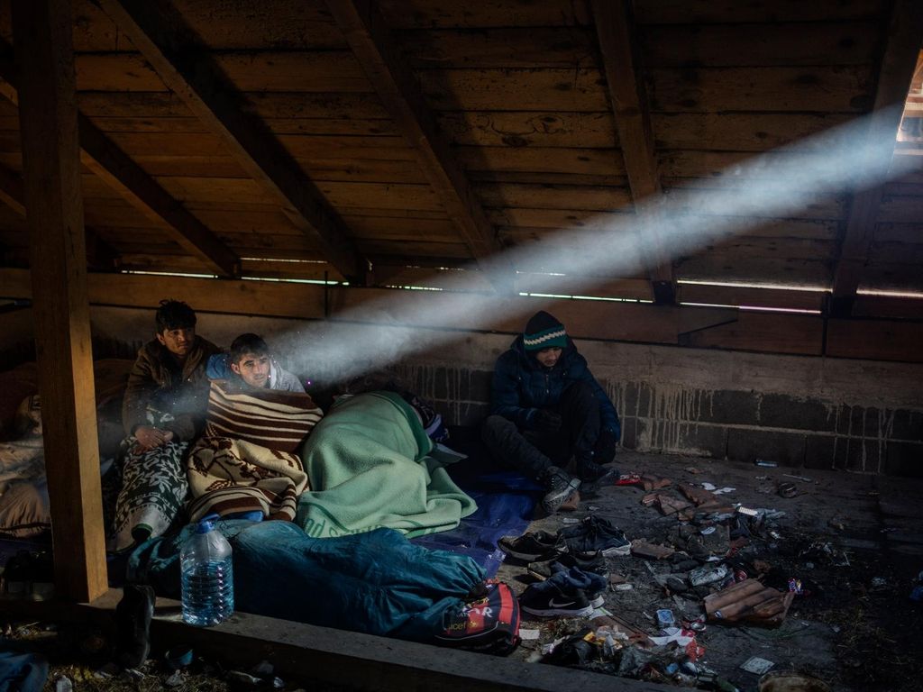 Afghan migrants wake up inside a cabin they use to sleep during their journey through the mountains of Bosnia to cross the border. JM Lopez / The National