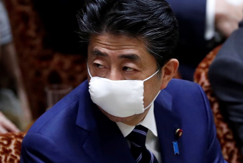 Japan's Prime Minister Shinzo Abe wears a protective face mask as he attends an upper house parliamentary session, following an outbreak of the coronavirus disease in Tokyo April 1, 2020. — Reuters pic