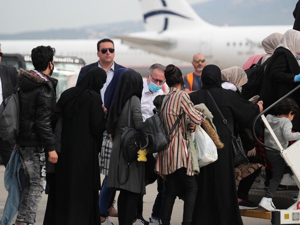 Deputy Migration Minister Giorgos Koumoutsakos waved the refugees off at Athens airport. Reuters