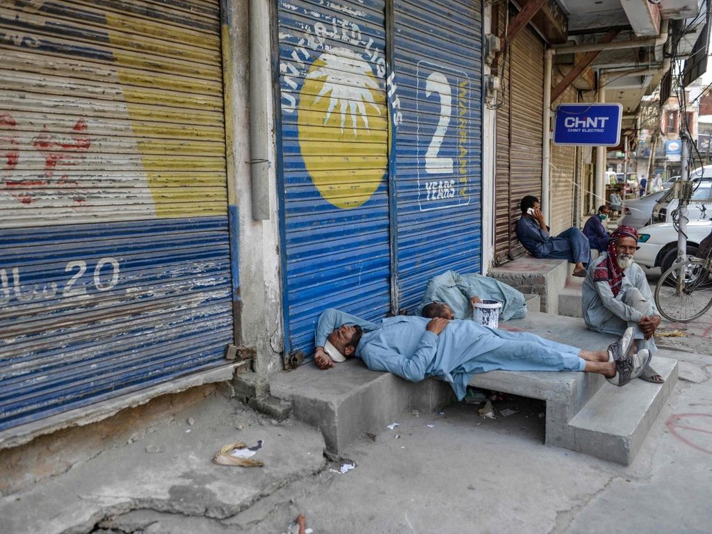 Labourers sleep near a market closed for the week-end in Rawalpindi on June 6, 2020. / AFP / Farooq NAEEM
