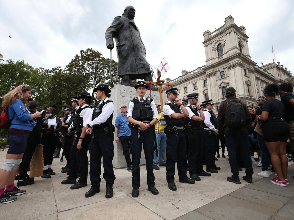 Police stand around the Winston Churchill statue ahead of a rally at the Nelson Mandela statue in the square, to commemorate George Floyd, on the day of his funeral, in Parliament Square, London, Tuesday June 9, 2020 AP