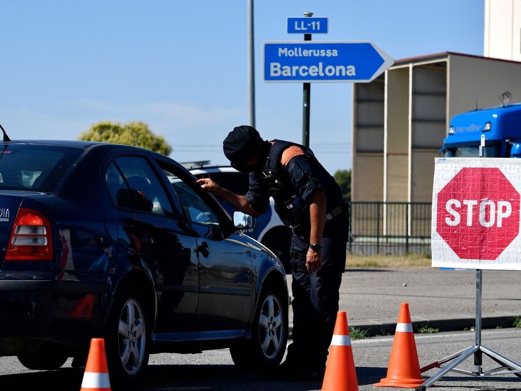 A member of the Catalan regional police force Mossos d'Esquadra controls a checkpoint on the road leading to Lleida AFP