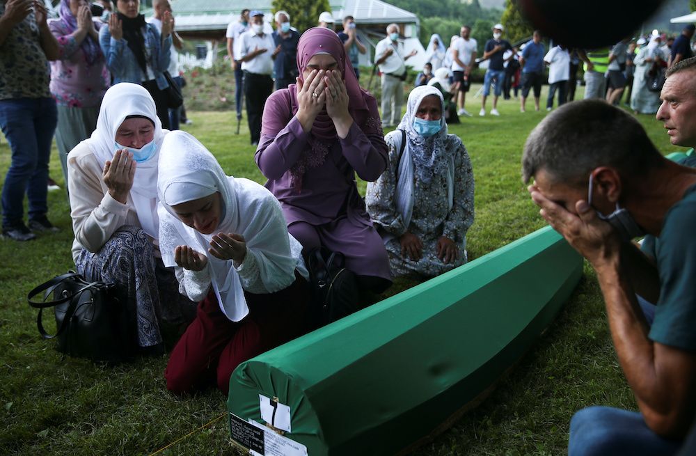 Bosnian Muslim women cry next to a coffin at a graveyard in Potocari, near Srebrenica, Bosnia and Herzegovina July 10, 2020. — Reuters pic