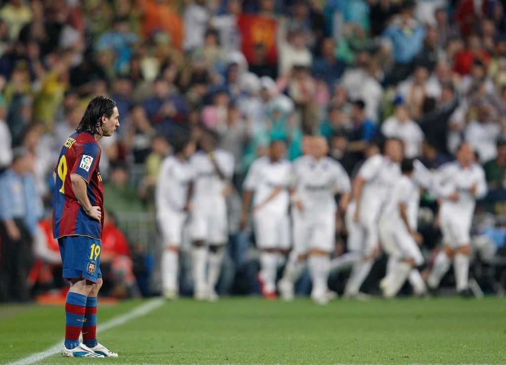 MADRID, SPAIN - MAY 07: Lionel Messi of Barcelona stands dejected backdropped by celebrating Real Madrid players during the La Liga match between Real Madrid and Barcelona at the Santiago Bernabeu Stadium on May 7, 2008 in Madrid, Spain. Barcelona lost the match 4-1. (Photo by Jasper Juinen/Getty Images)*** Local Caption *** Lionel Messi