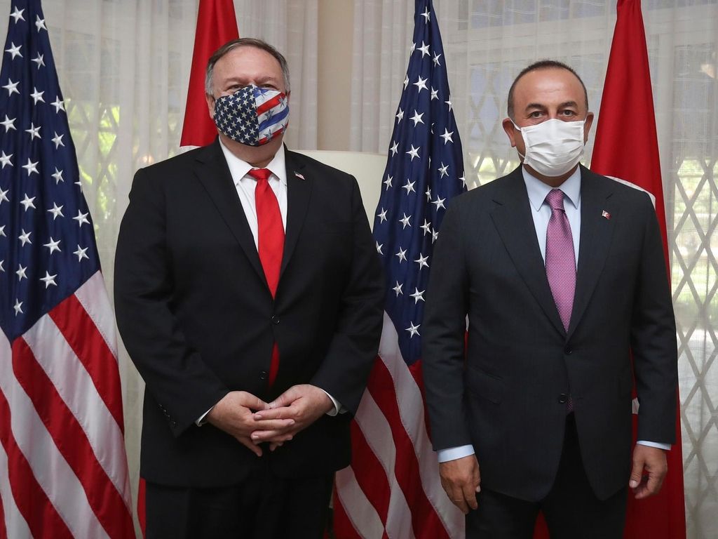 United States Secretary of State Mike Pompeo, left and Turkey's Foreign Minister Mevlut Cavusoglu pose for photos before a meeting, in Santo Domingo, Dominican Republic, Sunday, Aug. 16, 2020. Cavusoglu and Pompeo attended the swearing-in ceremony of Dominican Republic's President Luis Abinader.(Cem Ozdel/Turkish Foreign Ministry via AP, Pool )