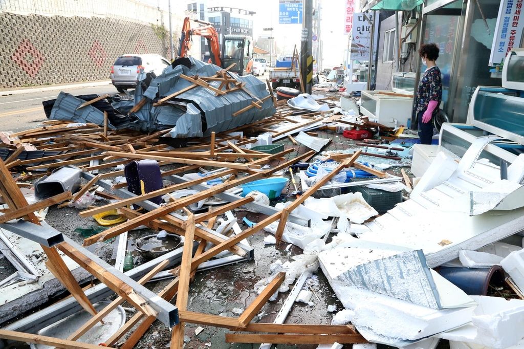 A woman looks at debris caused by Typhoon Maysak in Pohang, South Korea. Yonhap via Reuters