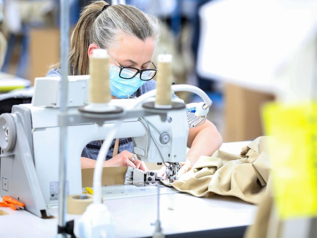 A machinist sews a protective gown for a worker in the U.K. National Health Service (NHS) at the Burberry Group Plc factory in Castleford, U.K., on Tuesday, April 21, 2020. The U.K. ran the risks running out of protective equipment for its hospital staff as half the doctors working in high-risk areas reported supply shortages in an April survey by the British Medical Association. Photographer: Chris Ratcliffe/Bloomberg