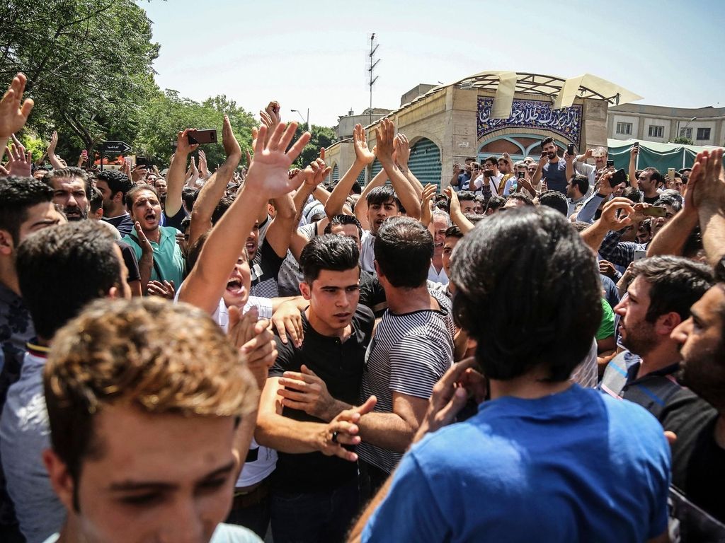 In this June 25, 2018 file photo, a group of protesters chant slogans at the main gate of the Old Grand Bazaar, in Tehran, Iran AP