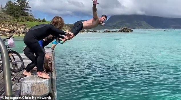 Jump: Chris shared a picture and video of himself jumping off a jetty and diving into the water with his kids and friends