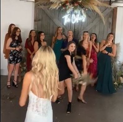 The wedding guest viciously snatches the bouquet from another woman's hand