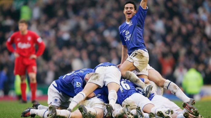 Tim Cahill celebrates as the Everton team on goal scorer Lee Carsley
