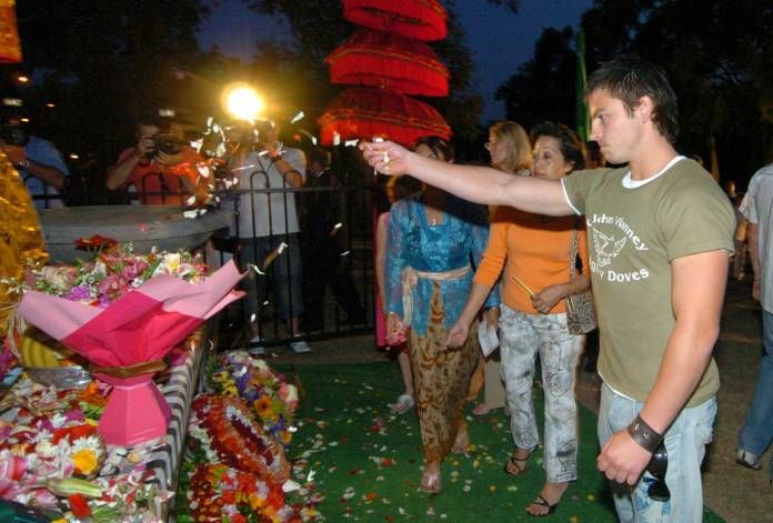 Jake Ryan, a survivor of the 2002 Bali bombing, throws rose petals over a shrine on the Gold Coast to commemorate the 2004 victims.