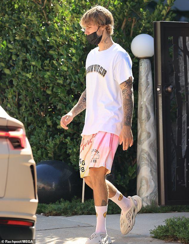 Casual: The Sorry singer wore a white Crenshaw Skate Club t-shirt and a pink pair of Honor the Gift Inner City shorts, as well as his own Drew shorts and Yeezy Foam runners
