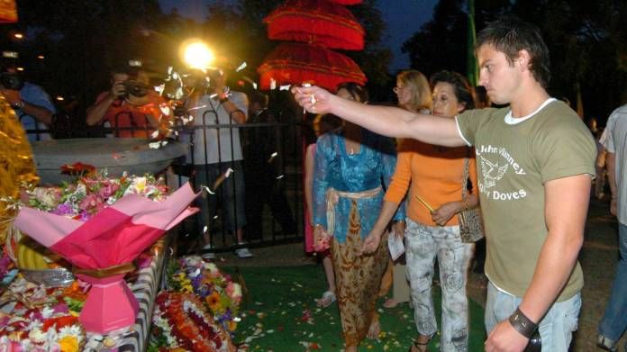 Jake Ryan, a survivor of the 2002 Bali bombing, throws rose petals over a shrine on the Gold Coast to commemorate the 2004 victims.