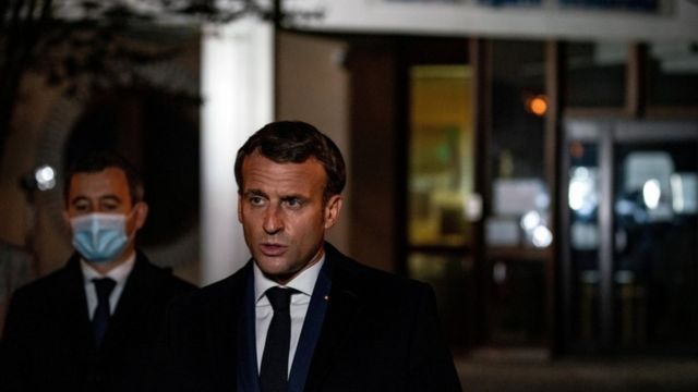 Macron speaks on the street at night