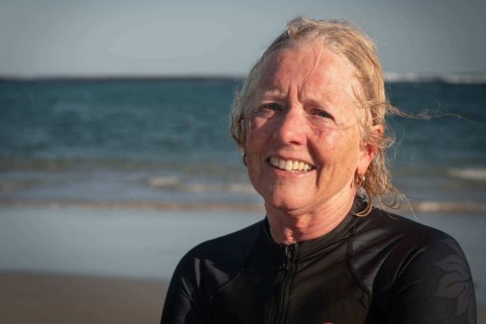 Jenni Hider-Smith A woman in a wetsuit stares at the camera on the beach