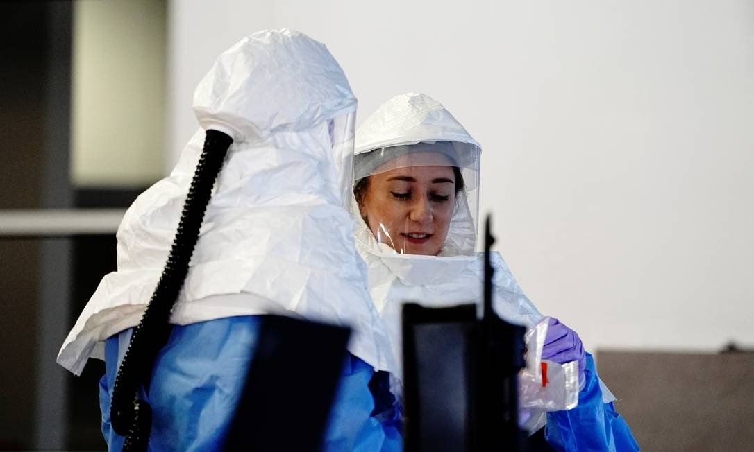Workers in air-purifying respirator suits process COVID-19 test samples at a drive-thru test site in Sioux Falls, South Dakota, USA. New cases of Covid-19 in the country broke a record, increasing tension at the end of the election race Photo: BING GUAN / REUTERS