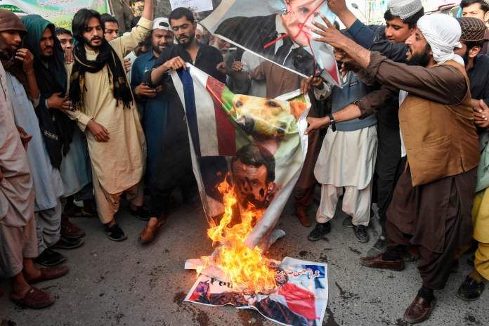 Protesters burn pictures of Macron during protests in Pakistan