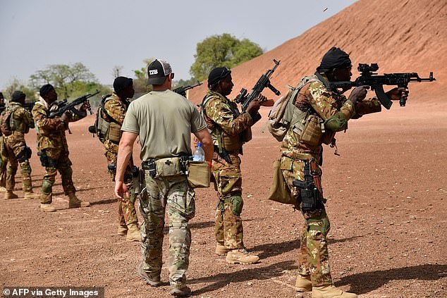 The increasing number of attacks in Niger and other West African countries has come despite the aid of French and US forces. Pictured: A US Army instructor walks next to Malian soldiers during an anti-terrorist exercise in the Kamboinse in 2018 (file photo).