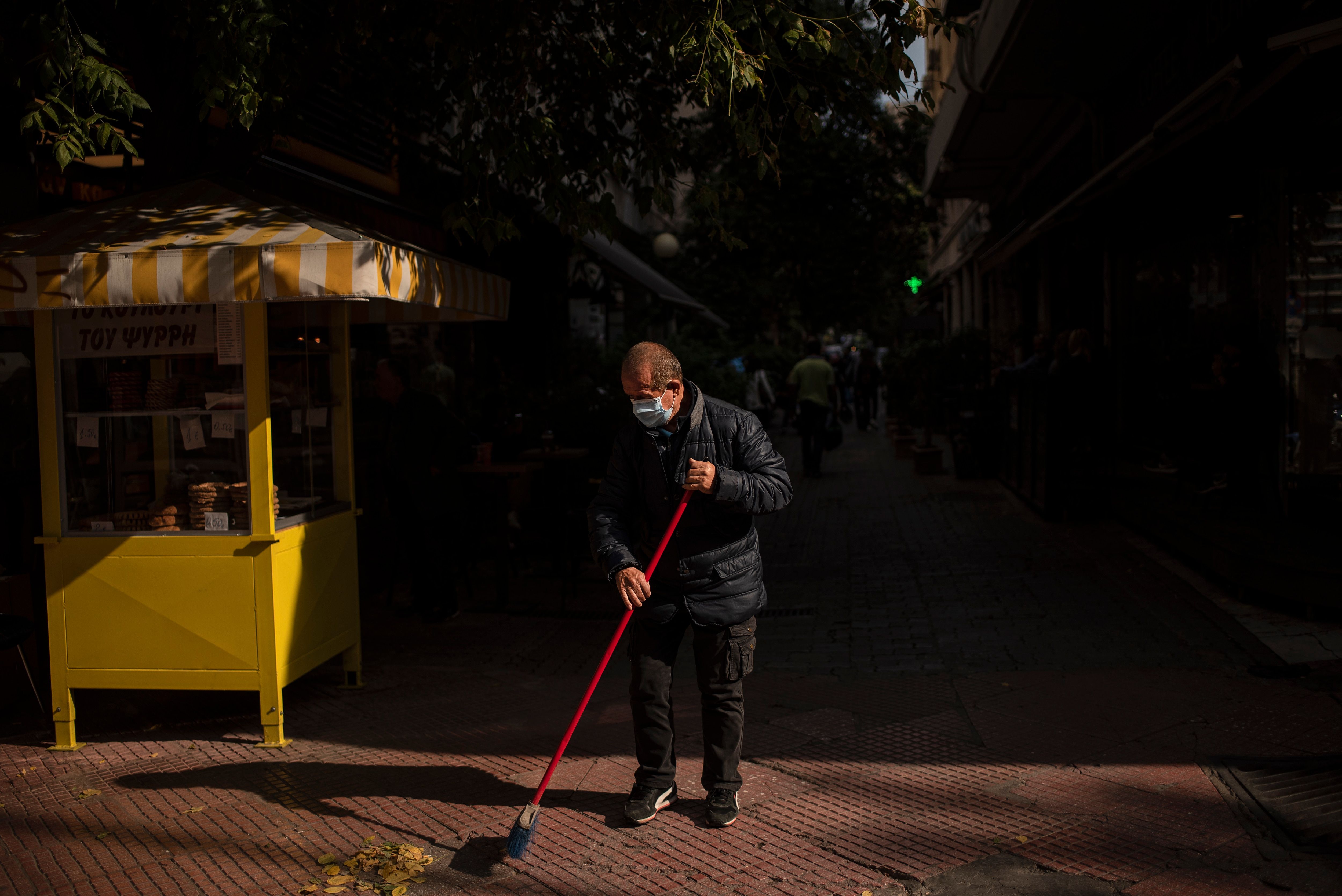 A man wearing a protective face mask cleans a street in the main business district of Athens, Greece, on October 30th.
