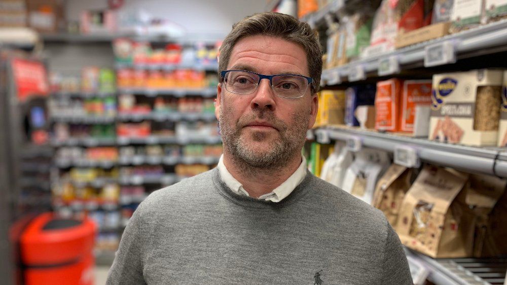 Click on the image to enlarge. Harald Kristiansen coop photo: Halvor Ripegutu Head of Communications at Coop Norway, Harald Kristiansen. Half-close picture of him in front of a store shelf. He is wearing a gray sweater and glasses.