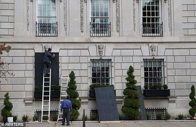 Businesses in major U.S. cities have been boarded up in anticipation of riots (workers pictured at the Hay-Adams Hotel across from the White House)