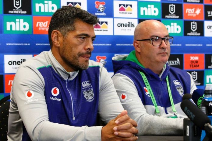 A rugby league coach and the manager of his team sit at a desk during a press conference.