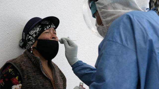 Health professional collects nose sample from an Ecuadorian woman for examination of covid-19
