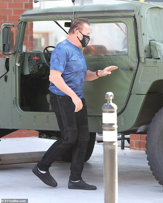 Favorite Car: Arnold wore a light blue camo top and black pants when he added a black face mask as he drove to his Hummer car