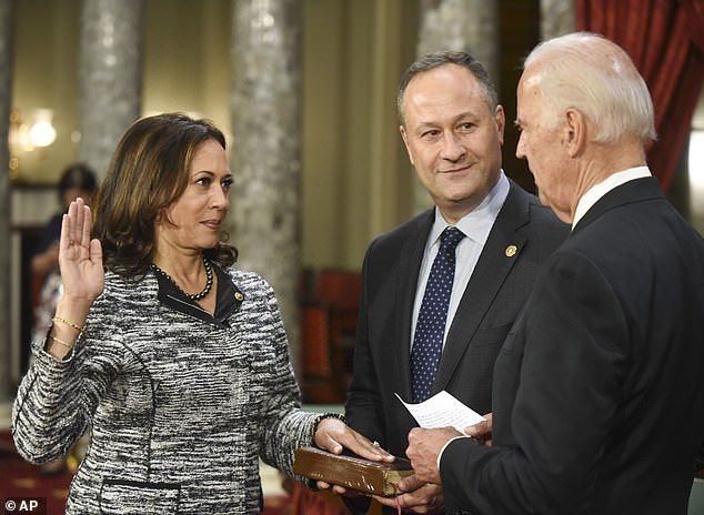 Joe Biden takes the oath of office to Harris as she was sworn in as a California Junior Senator back in 2017. Emhoff watches as he watches