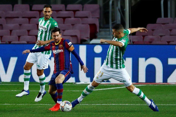 Guido Rodríguez tries to stop Messi.