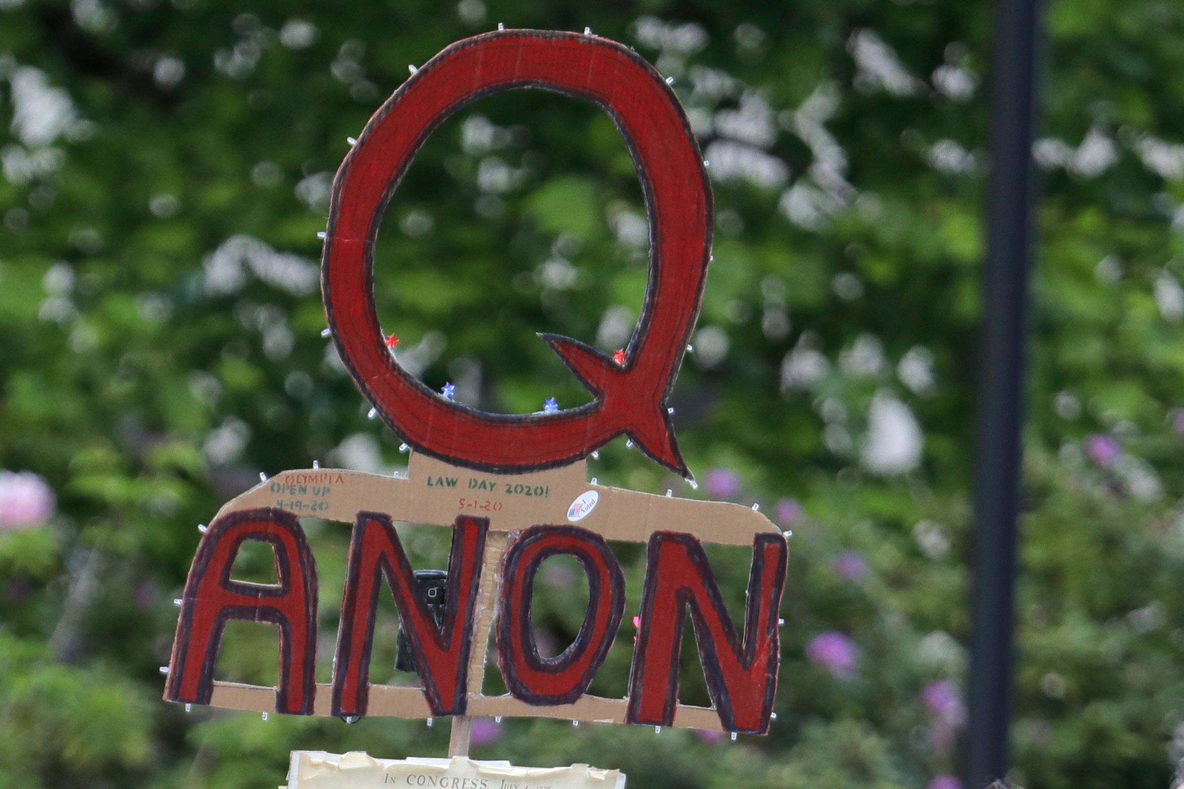 A person carries a sign promoting QAnon at a protest rally in Olympia, Washington, May 2020.