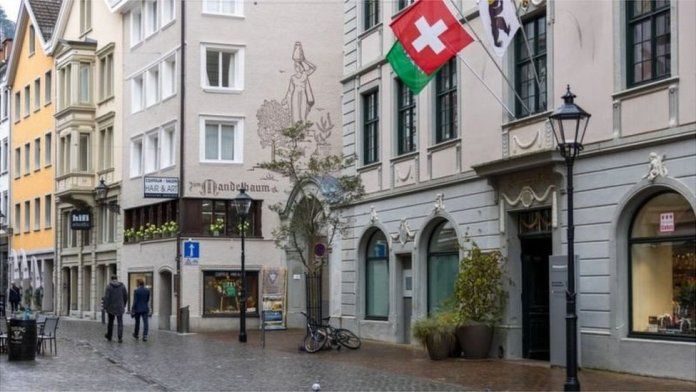 Zurich street with shops and Swiss flag