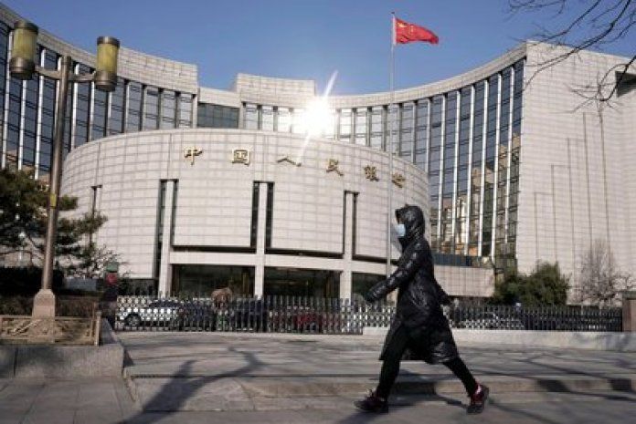 Woman wearing a mask in front of the headquarters of the People's Bank of China, the central bank, in Beijing, China, February 3, 2020. REUTERS / Jason Lee