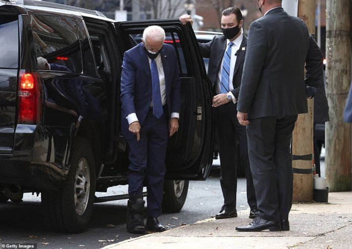 Joe Biden shows off his injured foot, where he wears a surgical boot