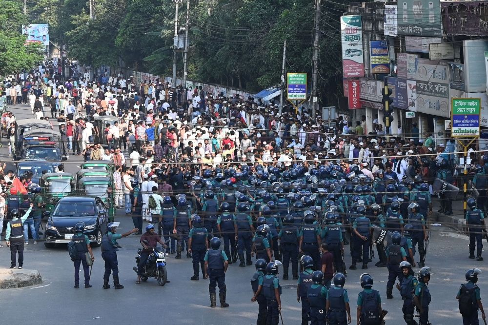 Police (front) stand guard in front of Bangladesh Nationalist party (BNP) activists during a rally demanding the resignation of the current government, the establishment of a non-partisan neutral government and the release of BNP chairperson Begum Khaleda Zia, in Dhaka on October 28, 2023. — AFP pic