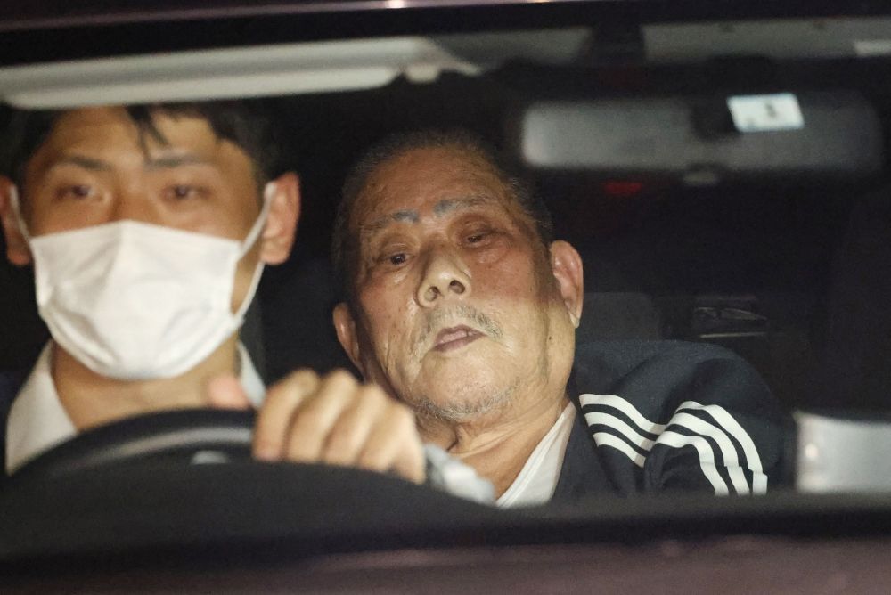 Suspect Tsuneo Suzuki (right), who barricaded himself in a post office, is transferred by a police vehicle in Warabi city, Saitama prefecture on October 31, 2023. — AFP pic