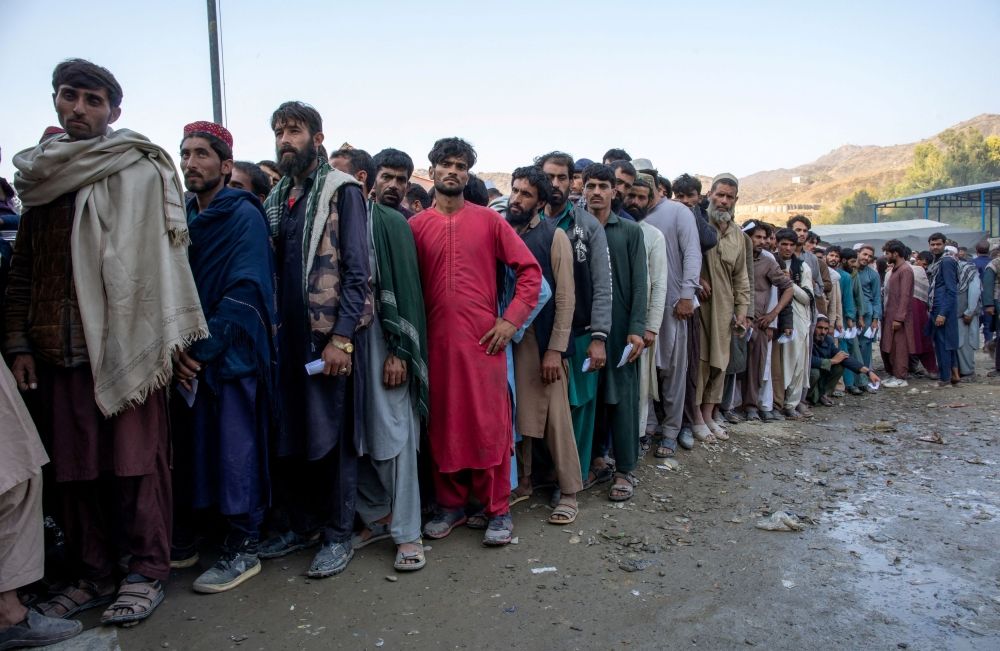 Afghan nationals stand in a queue as they wait to undergo screening to access humanitarian aid at the Torkham border crossing between Pakistan and Afghanistan, October 30, 2023. — The Norwegian Refugee Council handout pic via Reuters
