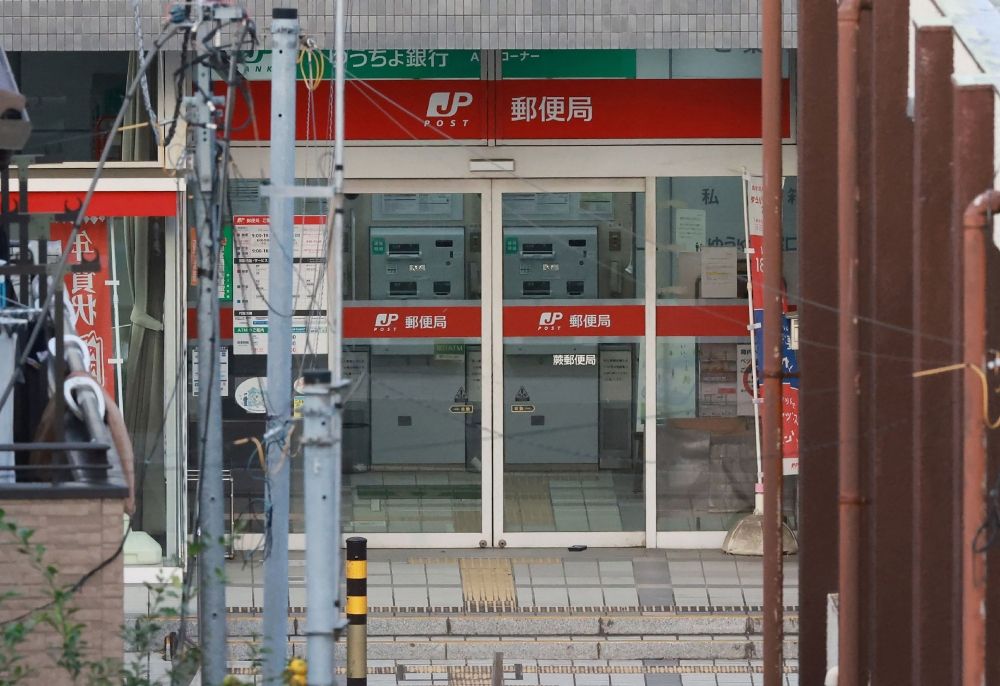 This picture shows the area around a post office where a suspected gunman has taken an unknown number of people hostage in Warabi City, Saitama. — AFP pic