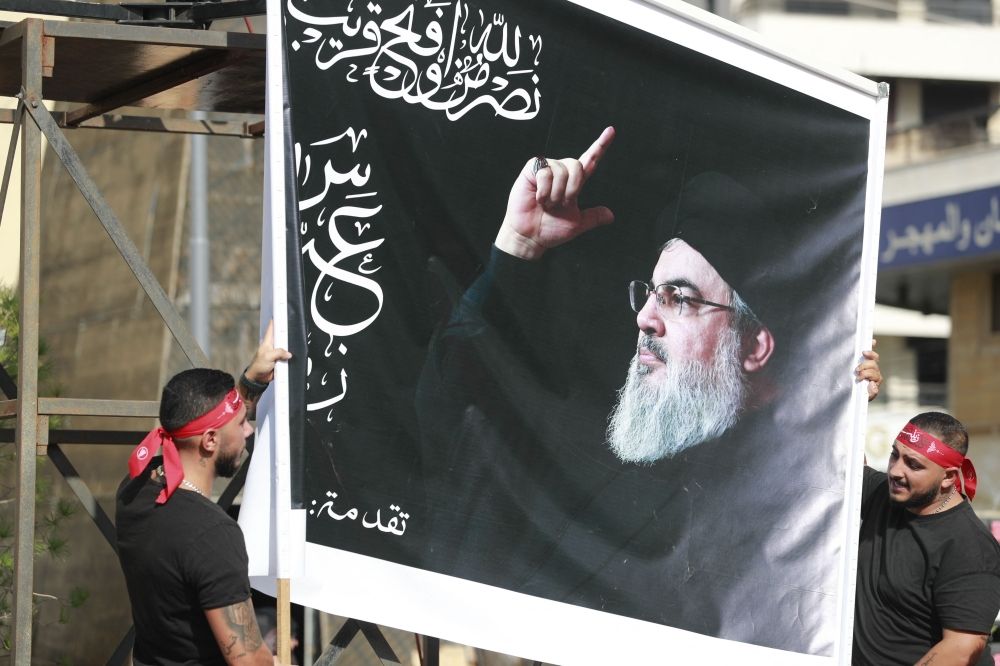 Supporters of the Lebanese Shiite movement Hezbollah hold a large image of its leader Hassan Nasrallah during his televised speech in the Lebanese capital Beirut’s southern suburbs on November 3, 2023. — AFP pic