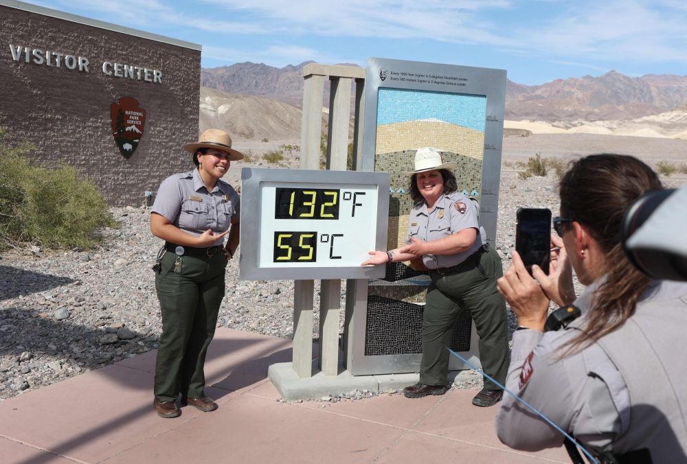 National Park Service Rangers Gia Ponce (L) and Christina Caparelli are photographed by Ranger Nicole Bernard next to a digital display of an unofficial heat reading at Furnace Creek Visitor Centre during a heat wave in Death Valley National Park in Death Valley, California July 16, 2023. — AFP pic