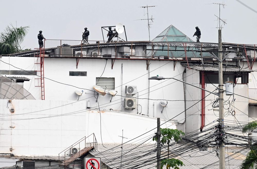 An Ecuadorean police squad approach the premises of Ecuador's TC television channel after unidentified gunmen burst into the state-owned television studio live on air on January 9, 2024, in Guayaquil, Ecuador, a day after Ecuadorean President Daniel Noboa declared a state of emergency following the escape from prison of a dangerous narco boss. — AFP pic