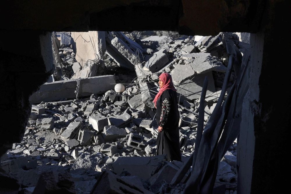 A woman walks amid the rubble following Israeli bombardment in Rafah in the southern Gaza Strip on January 13, 2024, amid ongoing battles between Israel and Palestinian militant group Hamas. — AFP pic