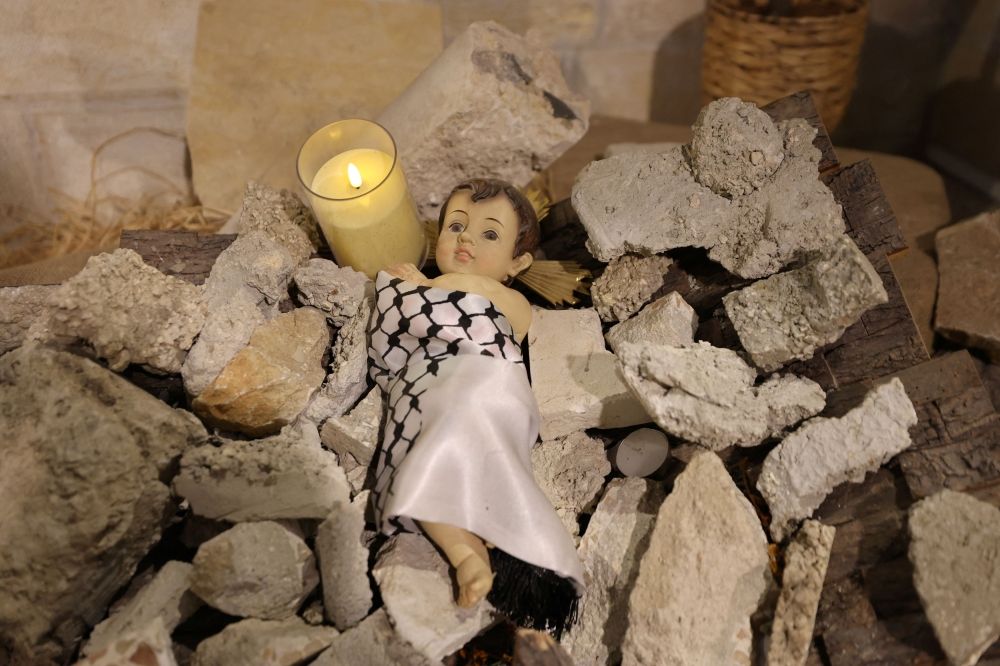 An installation that shows a figure symbolising baby Jesus lying amidst the rubble in a grotto at the Evangelical Lutheran Church, in Bethlehem. — Reuters pic