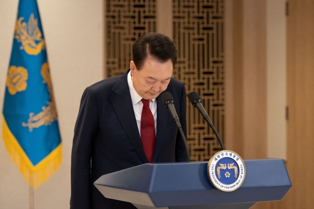 South Korean President Yoon Suk Yeol bows while delivering an address to the nation at the Presidential Office in Seoul, South Korea, December 12, 2024. — The Presidential Office handout pic via Reuters