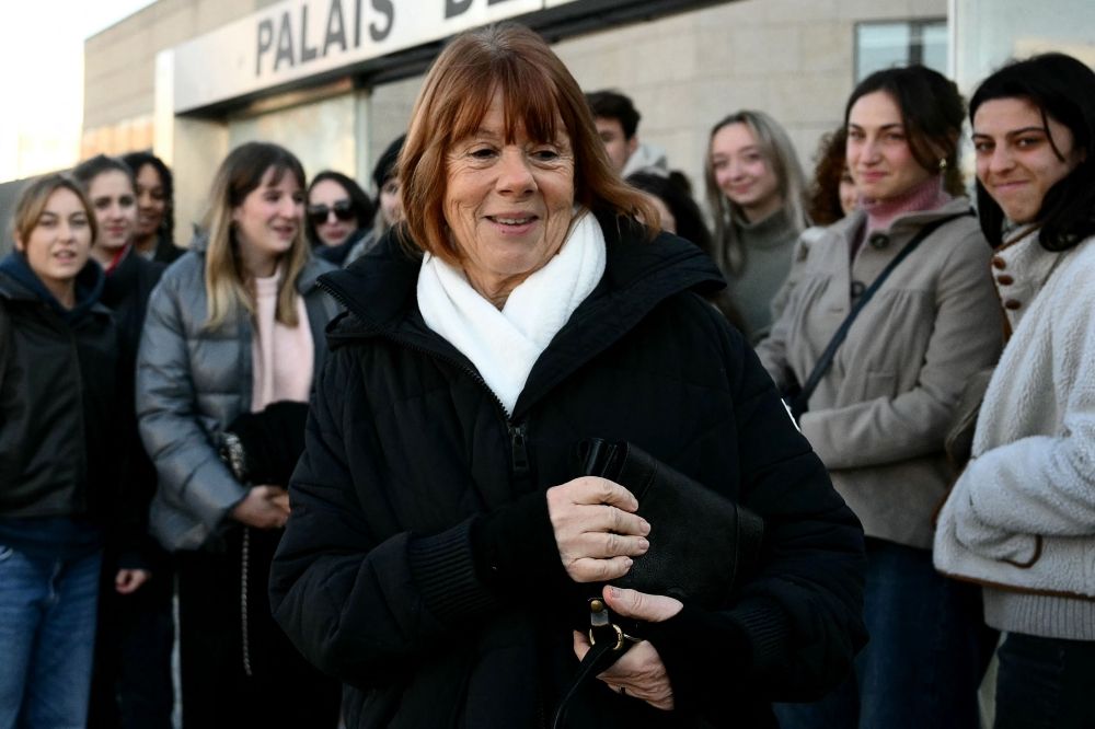 Gisele Pelicot (centre) reacts in front of young supporters, gathered at the Avignon courthouse, during the trial of her former partner Dominique Pelicot accused of drugging her for nearly ten years and inviting strangers to rape her at their home in Mazan, a small town in the south of France, in Avignon, on December 10, 2024.