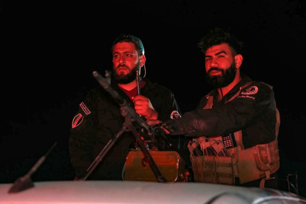 Members of Syria's security forces stand guard at a checkpoint at the entrance of Jaramana near Damascus early on May 2, 2025. — AFP pic