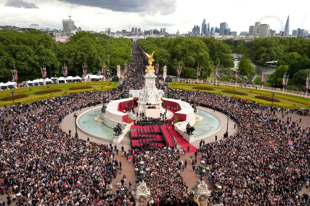People walk up The Mall towards Buckingham Palace ahead of a Red Arrows flypast following a military procession celebrating the 80th anniversary of VE Day also known as Victory in Europe Day, marking the end of the Second World War in Europe, in central London yesterday. — AFP pic